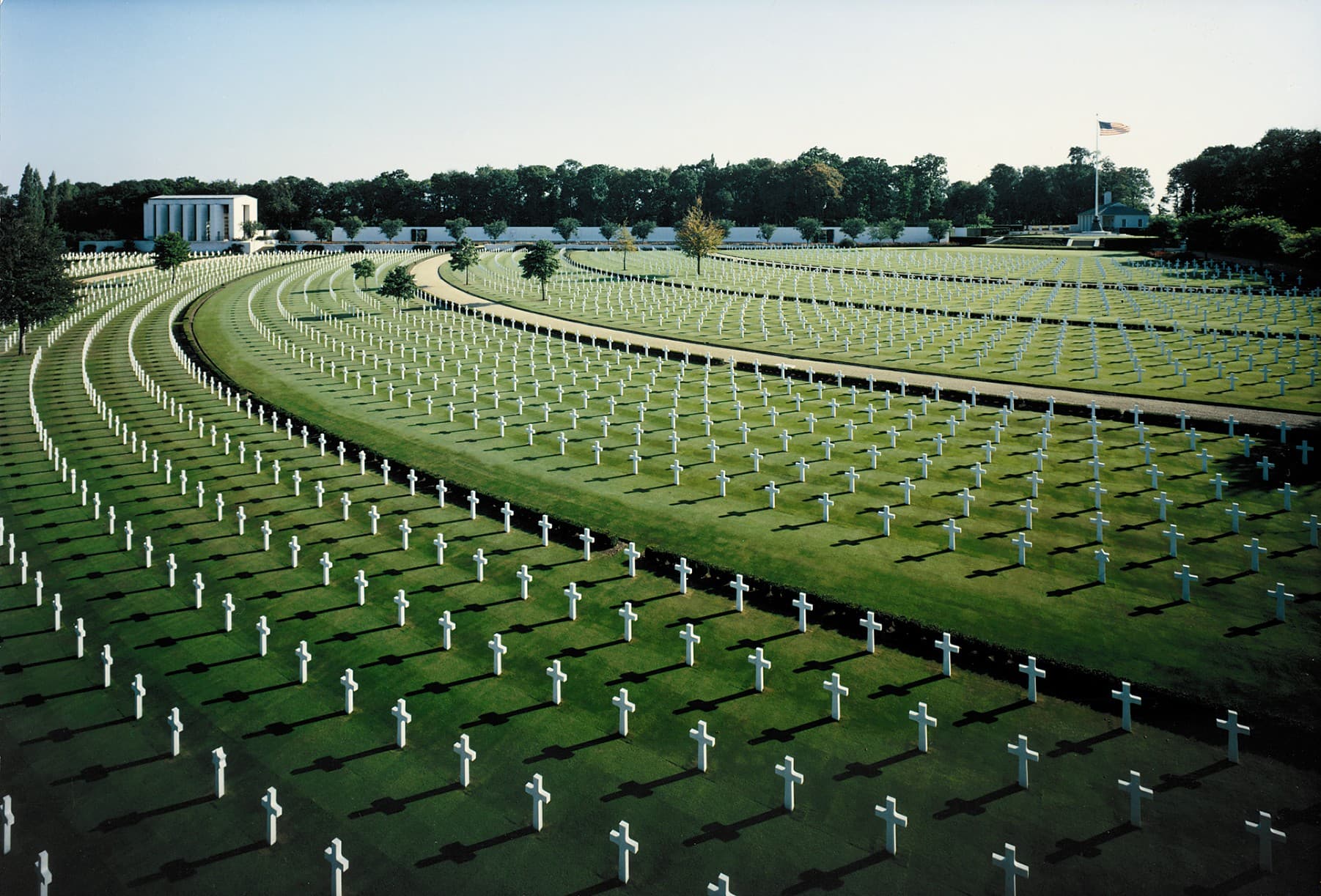 Rows of headstones and the memorial building at Cambridge American Cemetery.