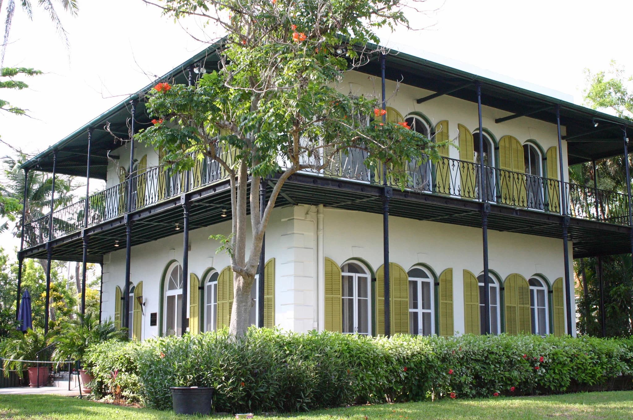 The Ernest Hemingway House behind tropical foliage in Key West